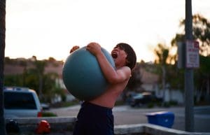 This is a person training with a sand filled plastic Atlas ball. We cover the use of Sandbags and other types of Atlas balls in our Strongman Blog